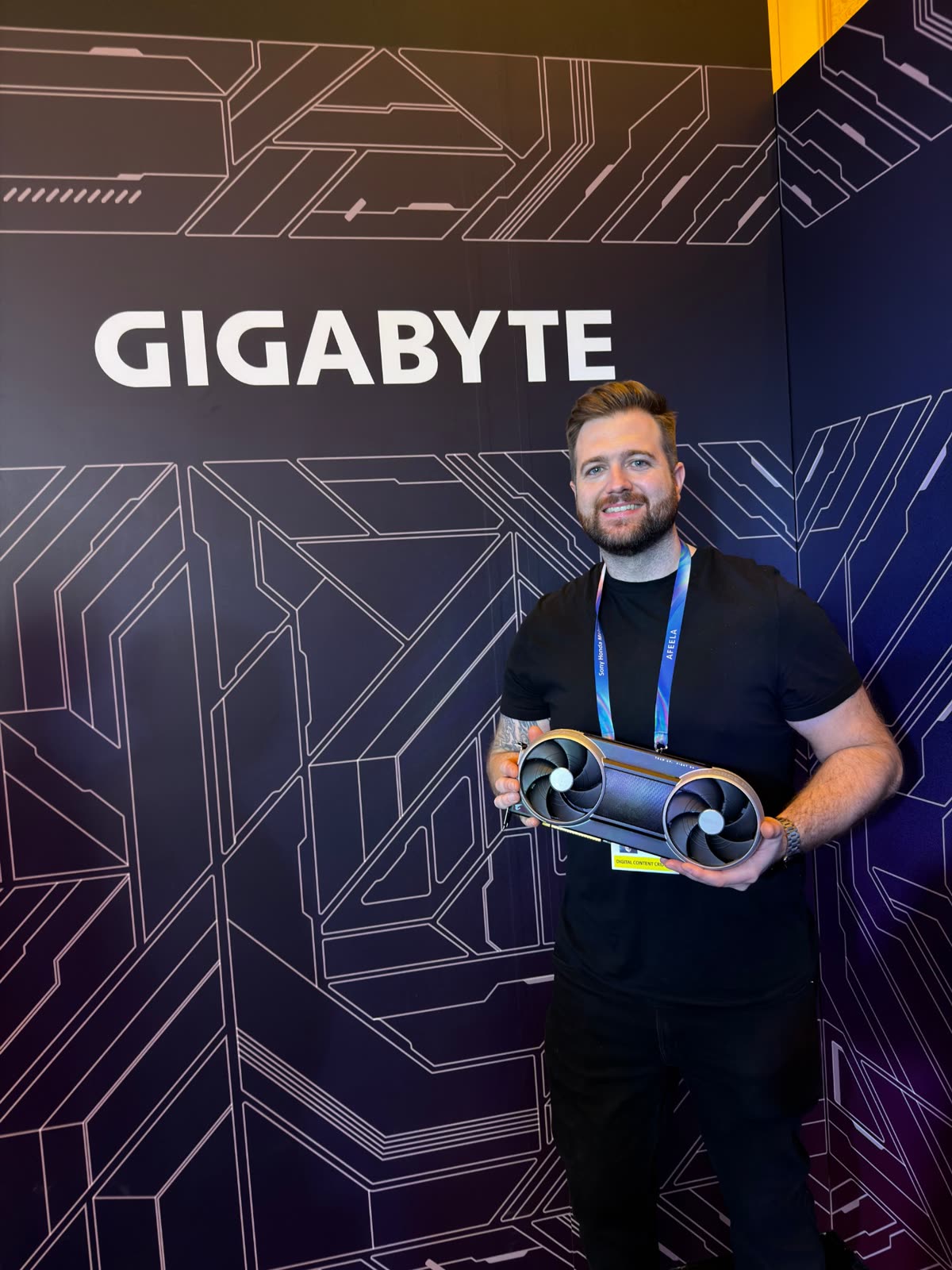 Alex holding a graphics card on the GIGABYTE stand at CES